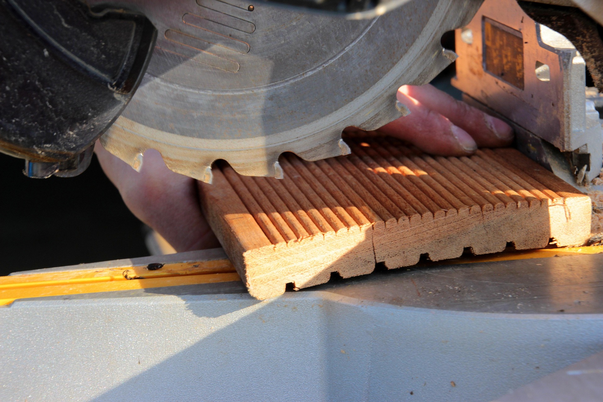 Carpentry — chop saw cutting deck board
